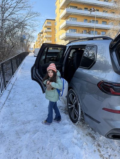 Barn med Tryggve-ryggs&auml;ck vid bil