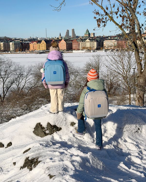 Barn med Rionell Tryggve-ryggs&auml;ckar vid Stockholms skyline